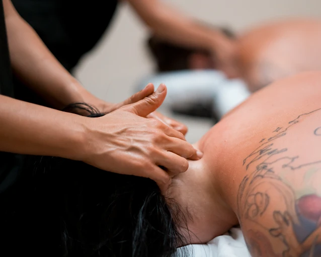 A massage therapist carefully preparing a treatment table